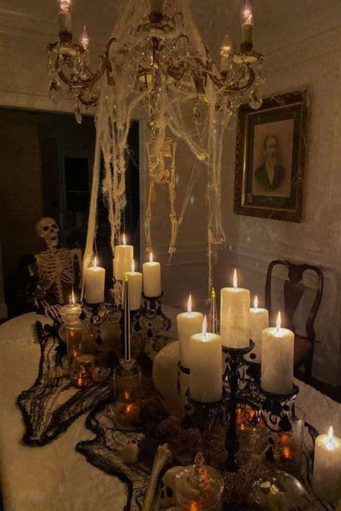 Cobweb chandelier dripping candlelight elegance.
