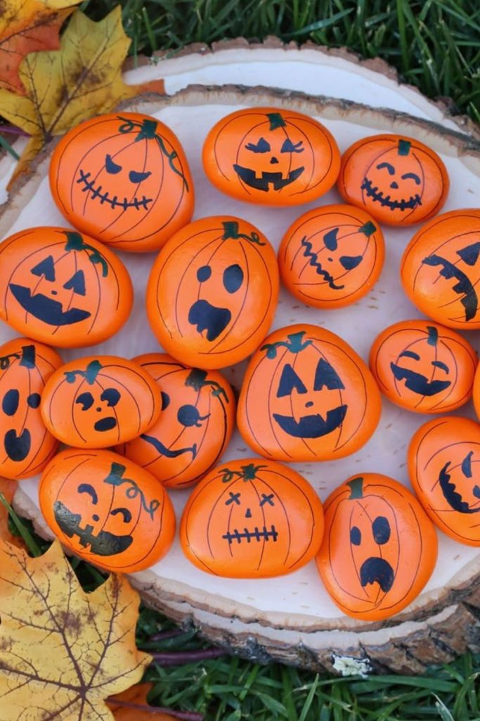 Painted rock pumpkins on garden path.