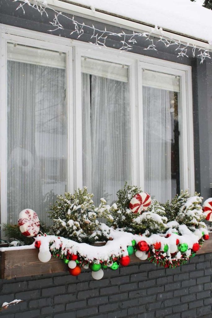 Snowy window box outdoor lights.