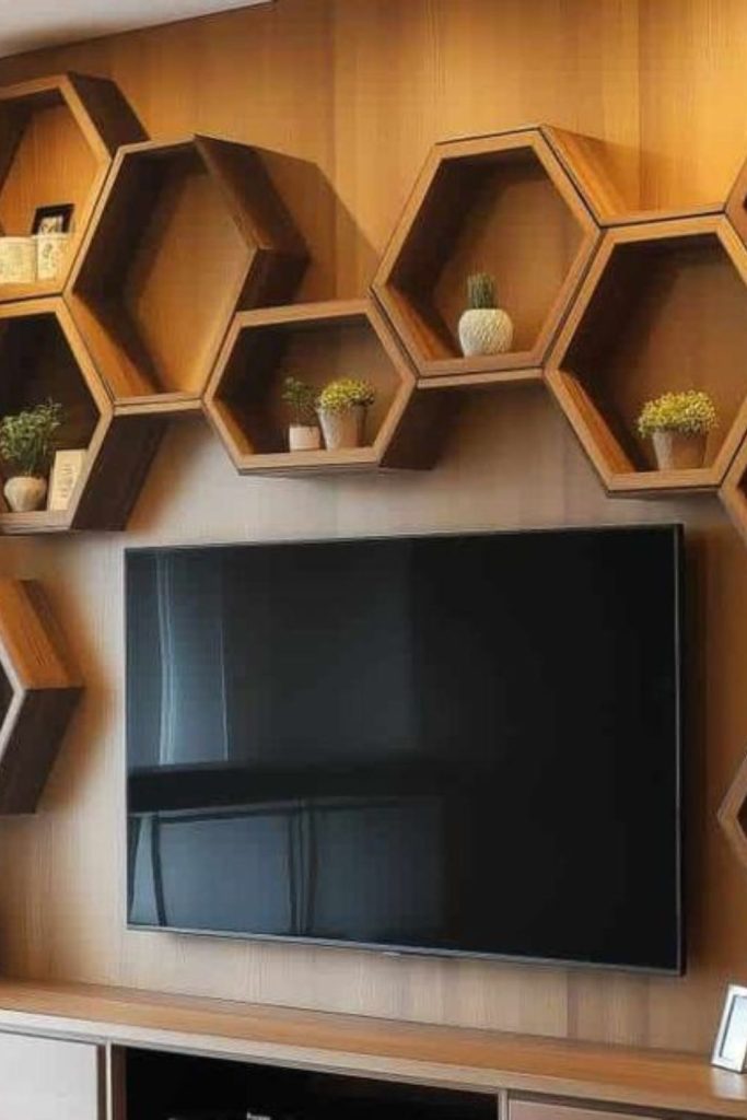 Hexagonal shelves surround television artistic display.