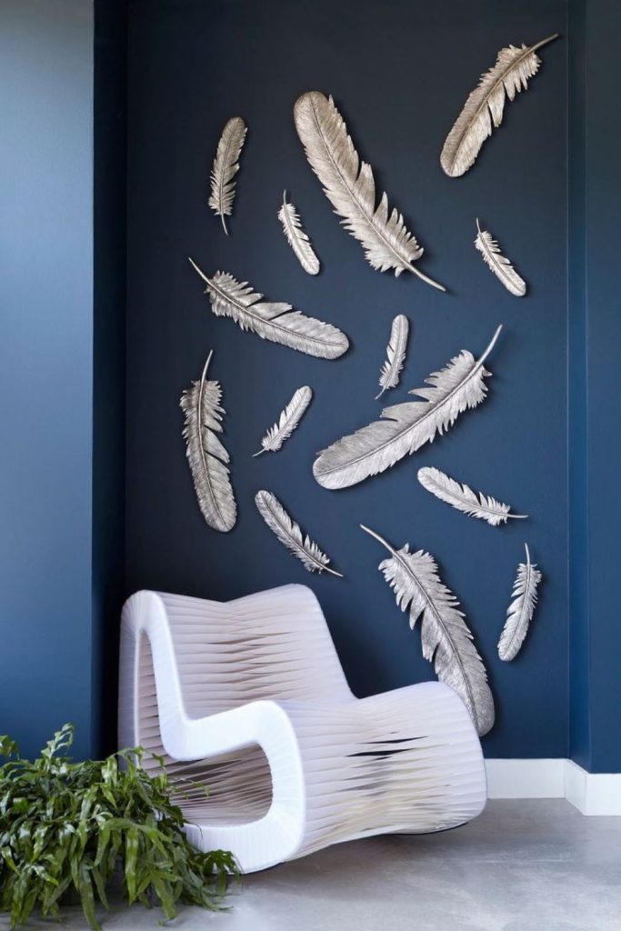 Thin metal feathers cascading down wall surfaces