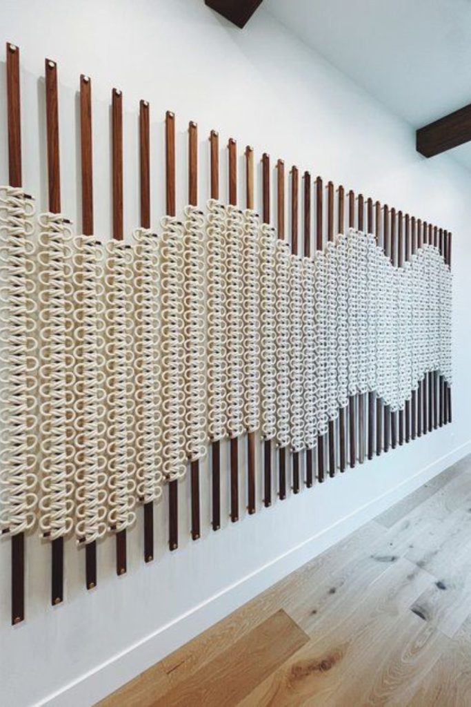 Knotted fabrics creating intricate textured wall tapestry