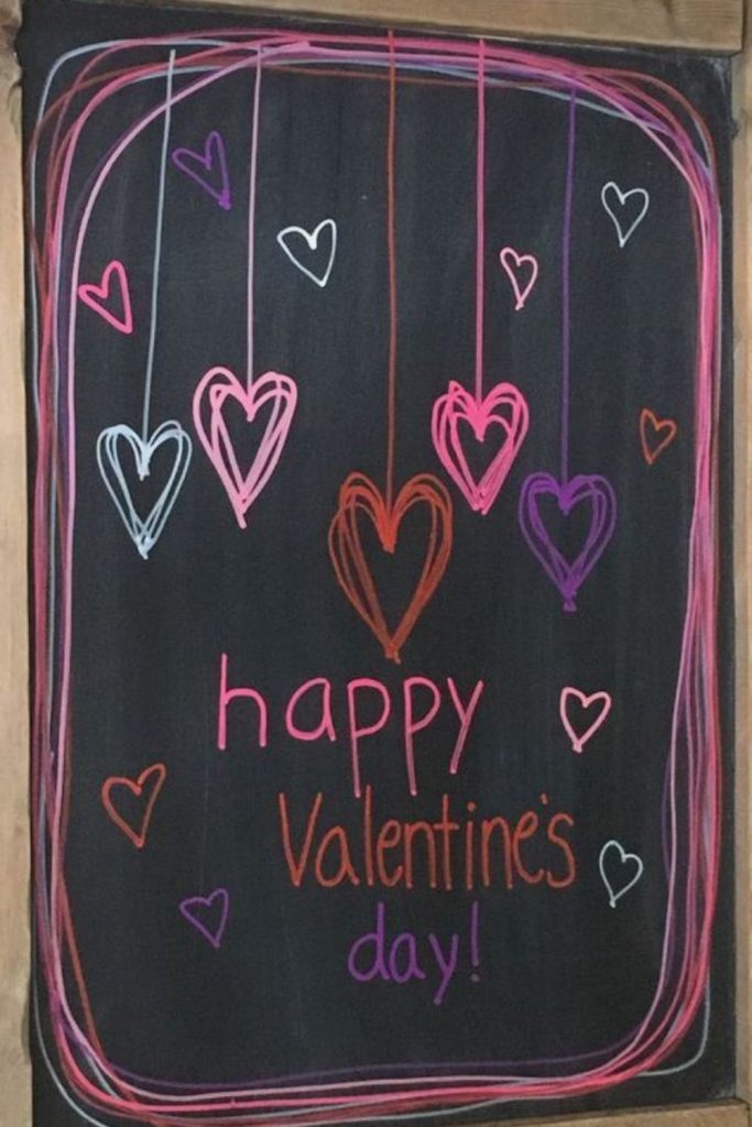 Chalkboard wall decorated with hearts and doodles.