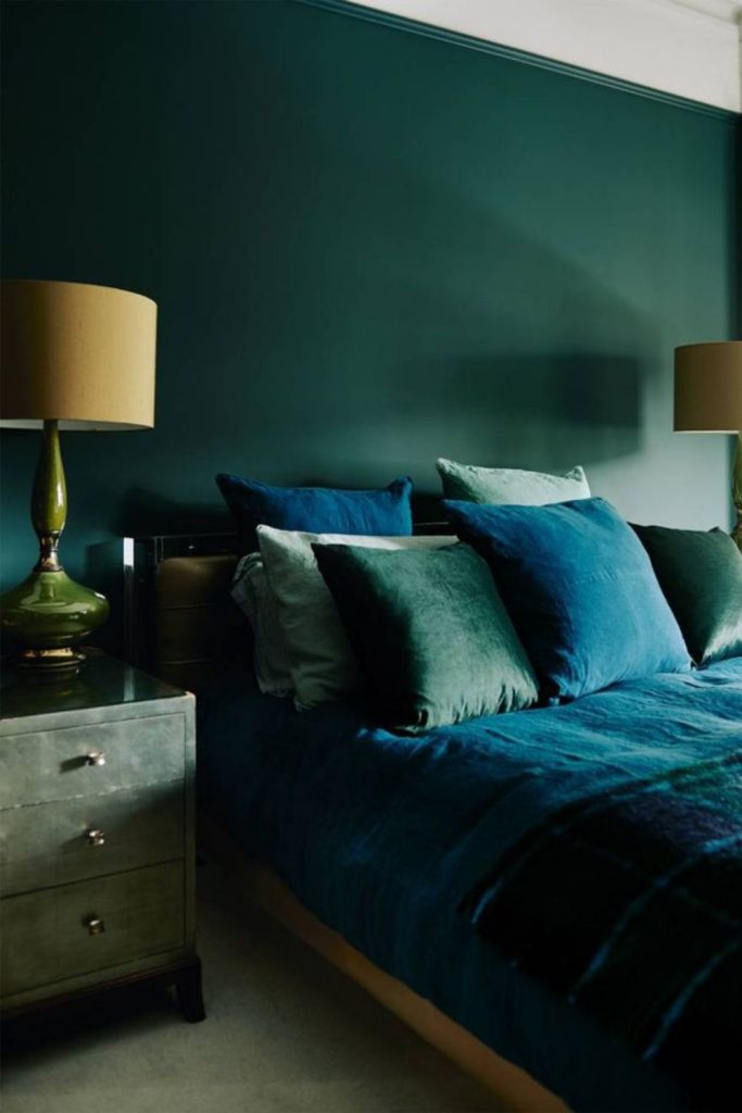 Emerald walls, brass lamp, small room