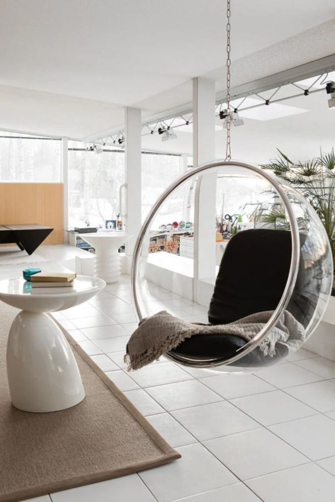 Bubble chairs float within neon curved spaces.