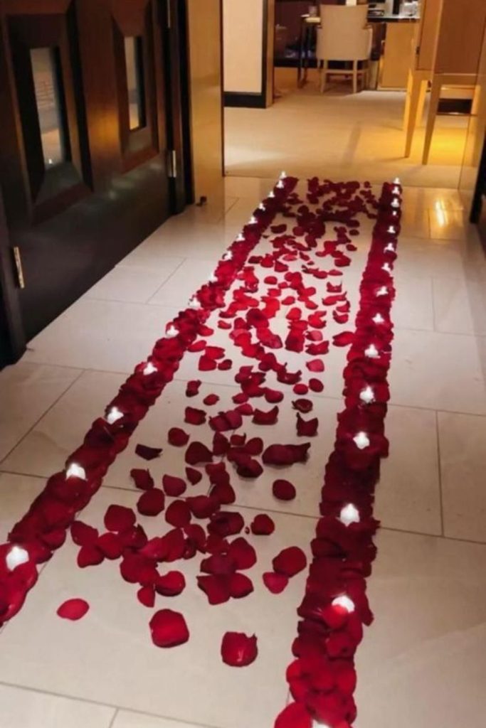 Scattered rose petals leading indoor walkway.