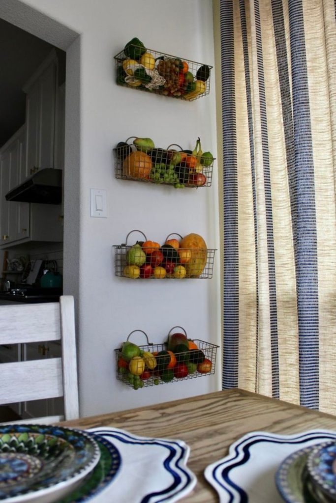 Wire baskets with fruits on wall
