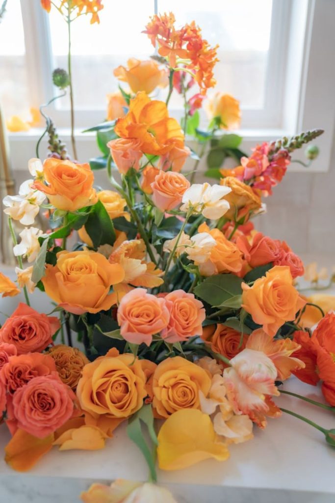 Sunset-orange roses with buttery ranunculus