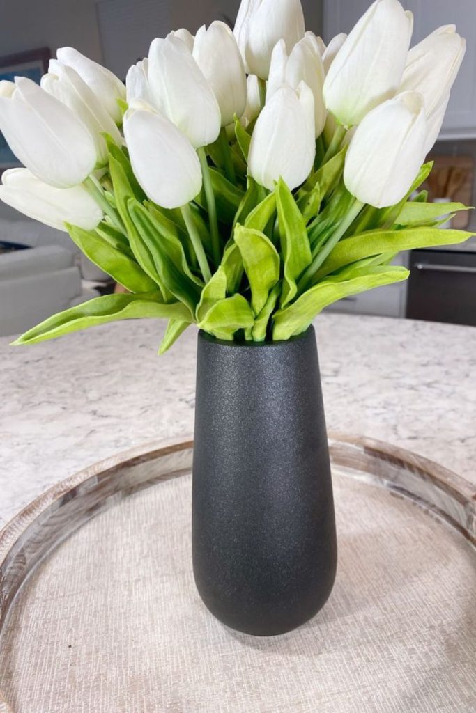 White tulips black vessel simplicity