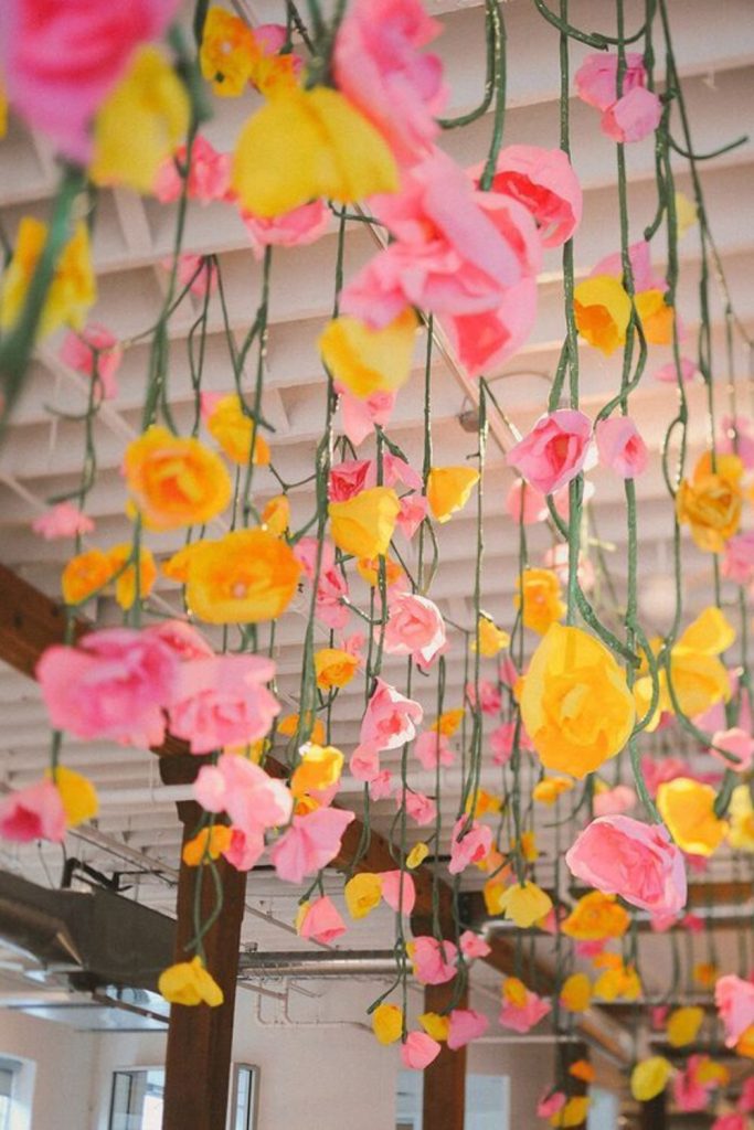 Hanging paper flowers creating floating illusion.