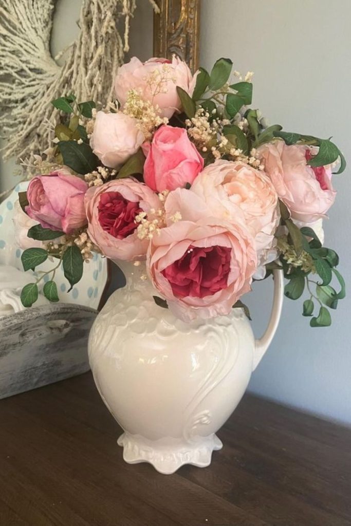 Ivory roses in chipped porcelain pitcher