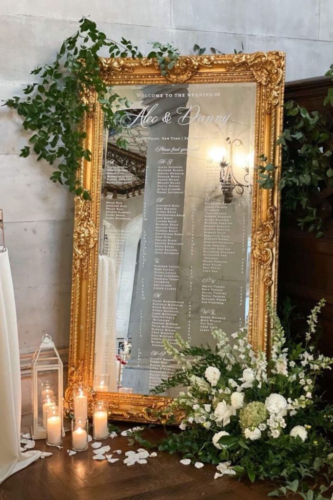 Antique mirror seating chart with floral accents.