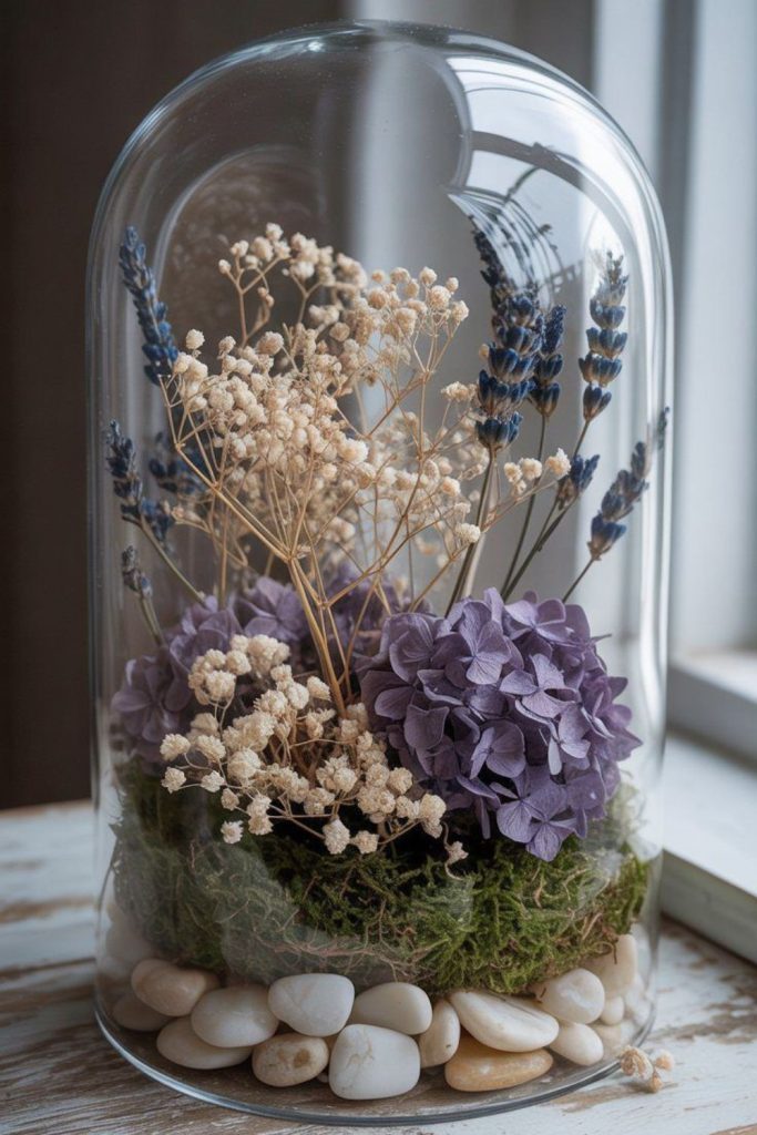 Glass cloche covering tiny wildflower arrangement.