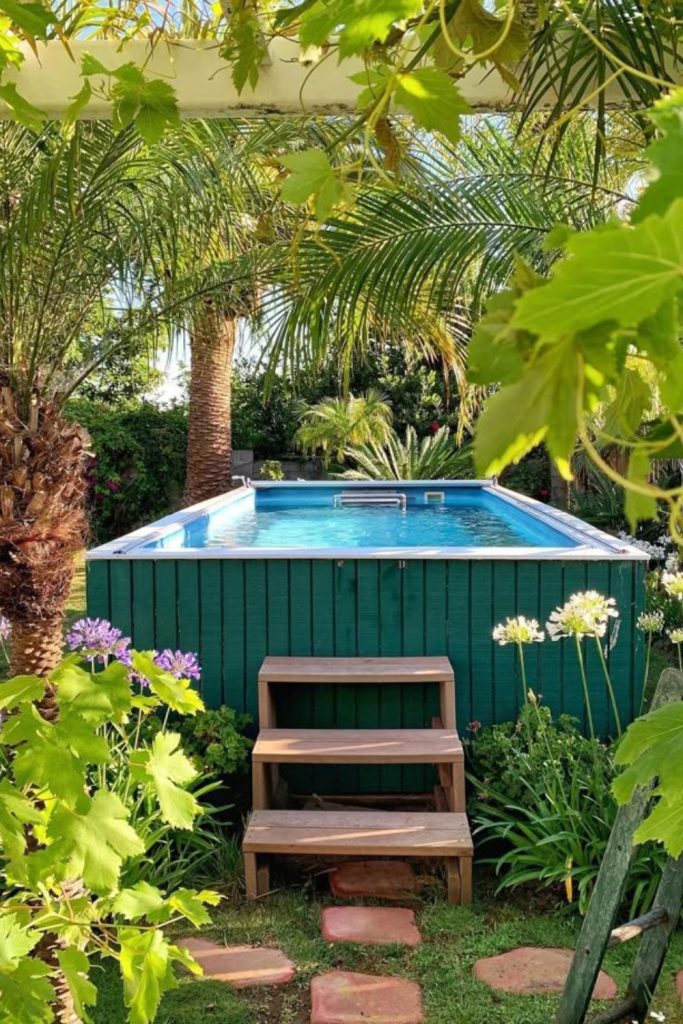 Lush garden surrounded pool, hidden greenery oasis feel.
