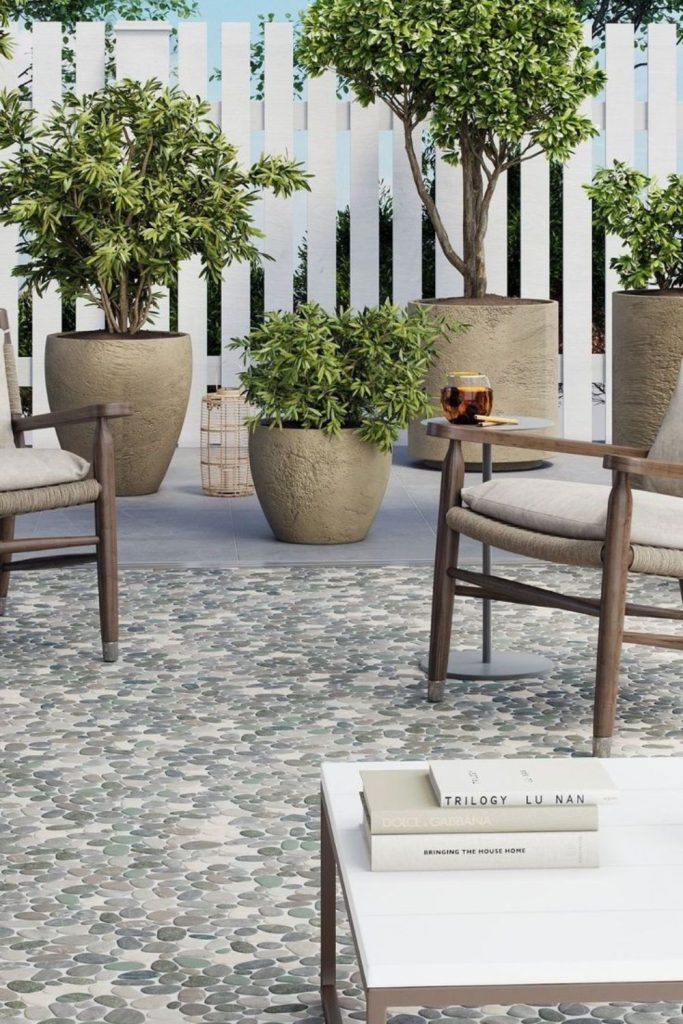 Pebble flooring beneath airy pergola.