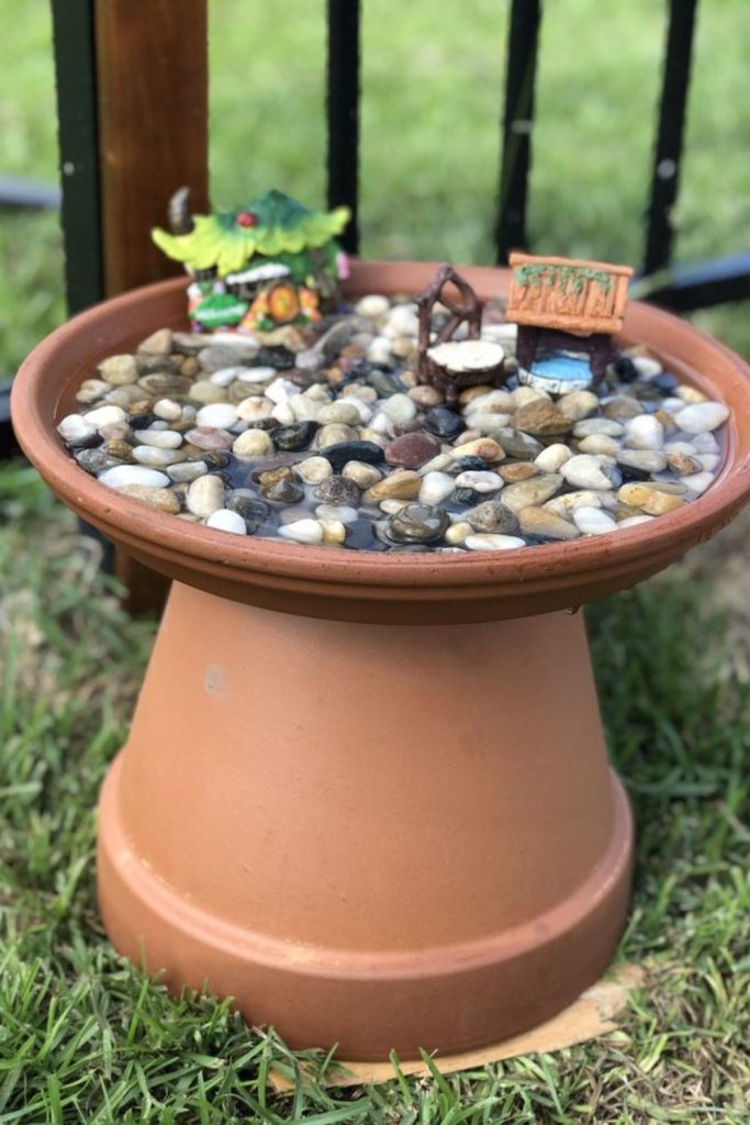 Rustic pebble bee bath garden setup.
