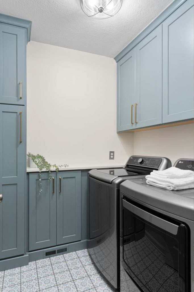 Dusty blue laundry room cabinets.