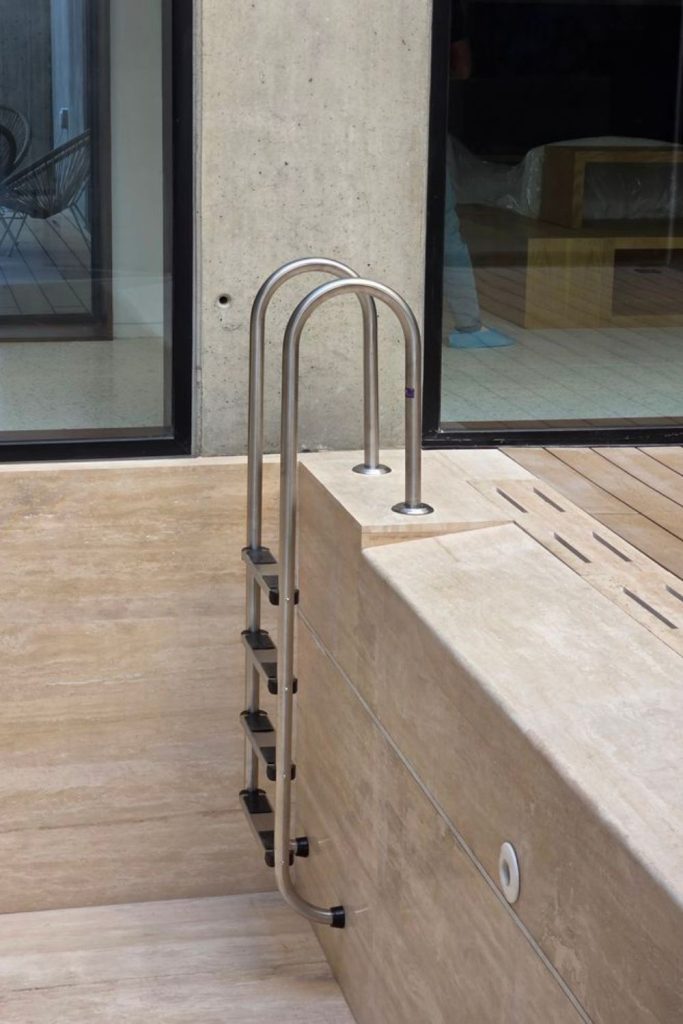 Gray composite modern pool ladder design.