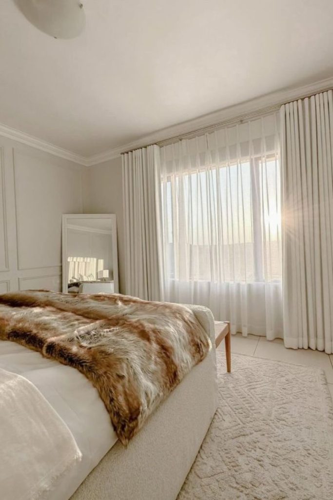 Ivory curtains with layered blackout blinds.