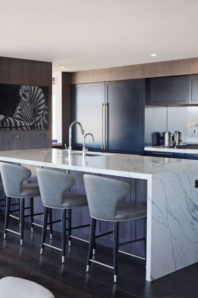 Marble waterfall kitchen island with sink.