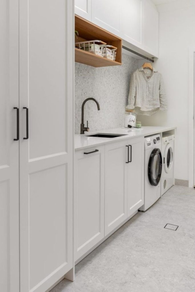 Minimal white laundry room cabinetry.