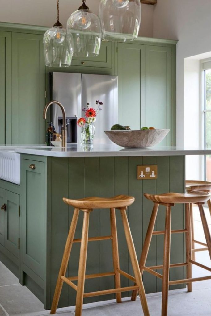 Olive green kitchen island with sink.