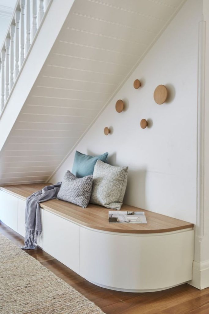 Fold-away storage bench beneath stairs.