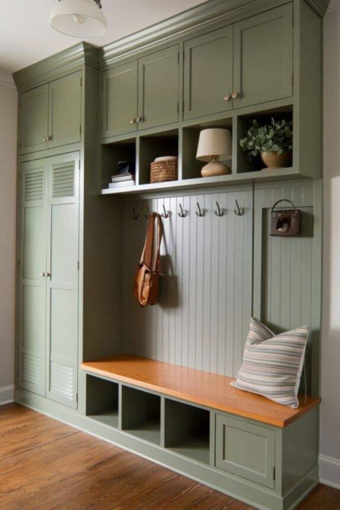 Sage green boot room with timber.
