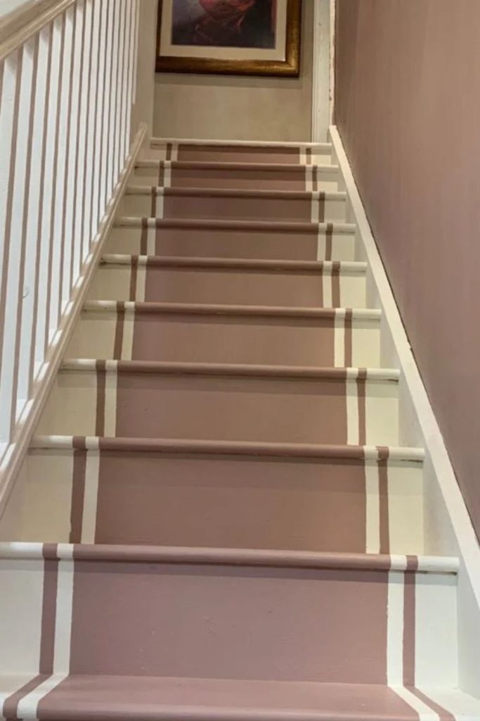 Blush pink staircase with brass details.