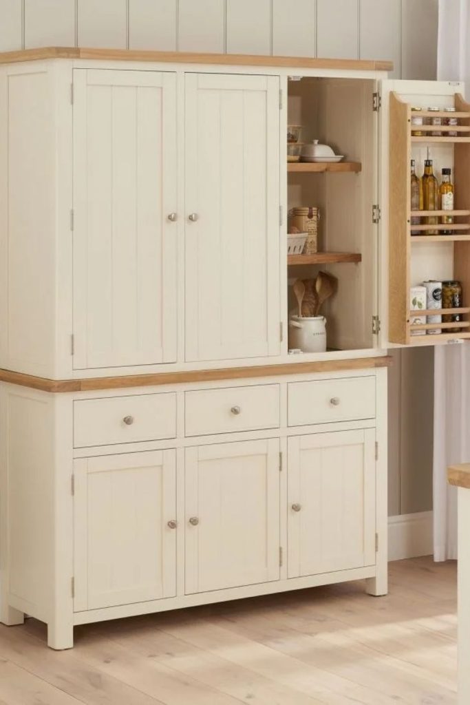 Cream cottage larder with wicker baskets.
