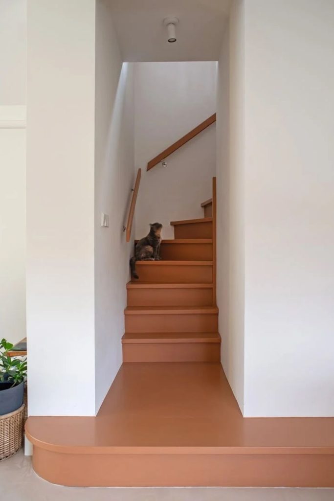 Terracotta staircase with natural wooden steps.