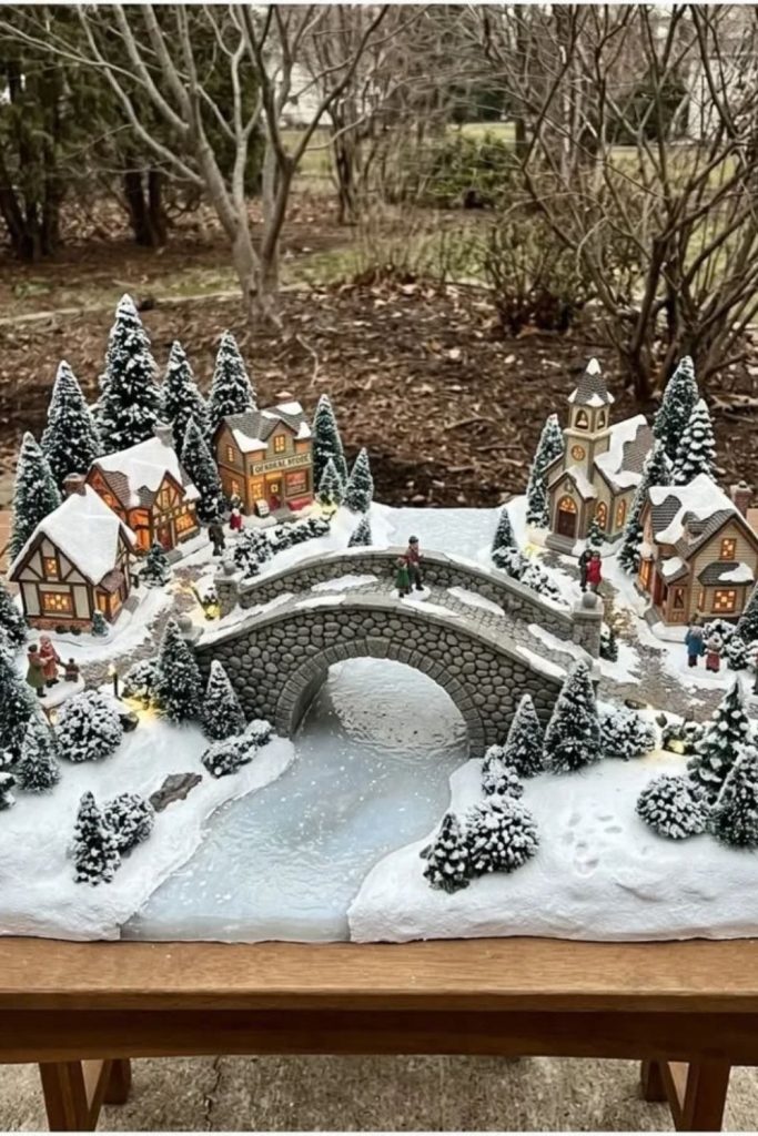 Snowy Christmas village surrounding frozen miniature lake.