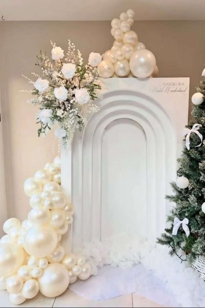 White Christmas balloon arch with sparkling silver accents.